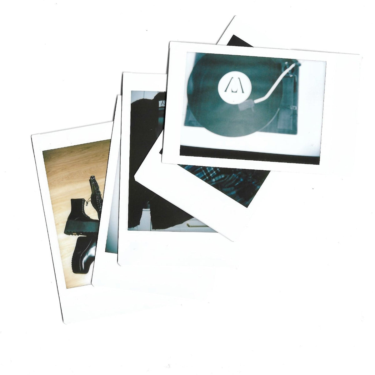 A stack of overlapping Polaroid-style instant photographs on a plain white background. The photos show abstract and cropped scenes, including a dark circular object with a white logo and another with a black-and-white object on a tan surface.
